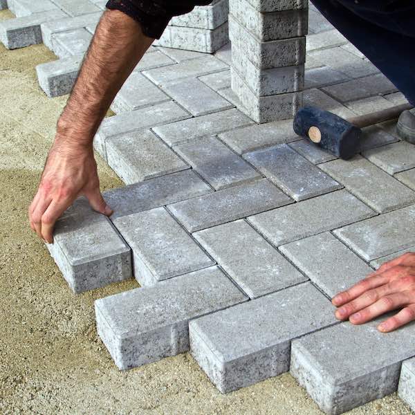 person laying down pavers